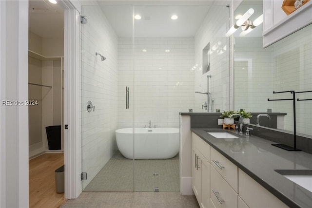 bathroom with tile walls, vanity, tile patterned floors, and shower with separate bathtub