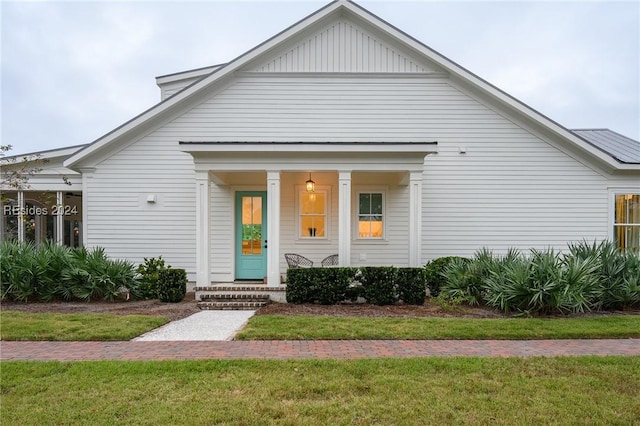 view of front of house with covered porch and a front yard