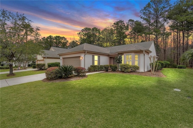 ranch-style house with a garage and a lawn