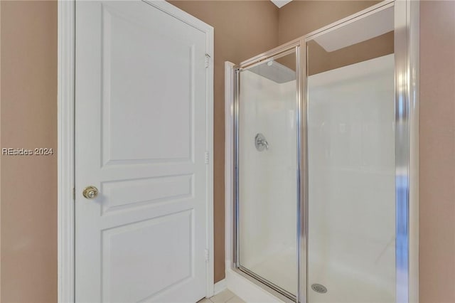 bathroom featuring tile patterned floors and a shower with shower door