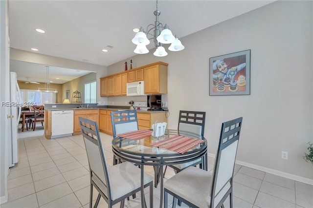 tiled dining space featuring an inviting chandelier and sink