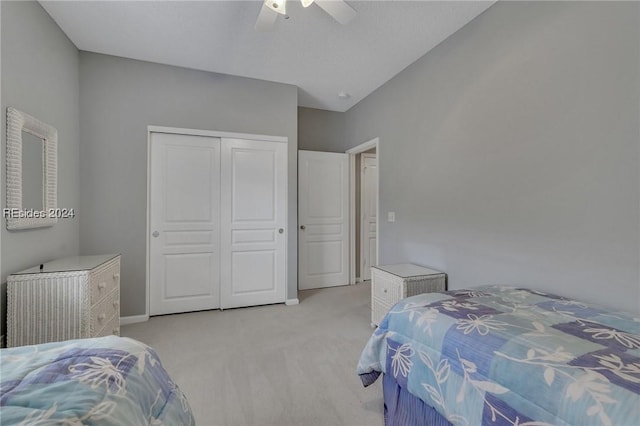 bedroom featuring ceiling fan, light colored carpet, and a closet