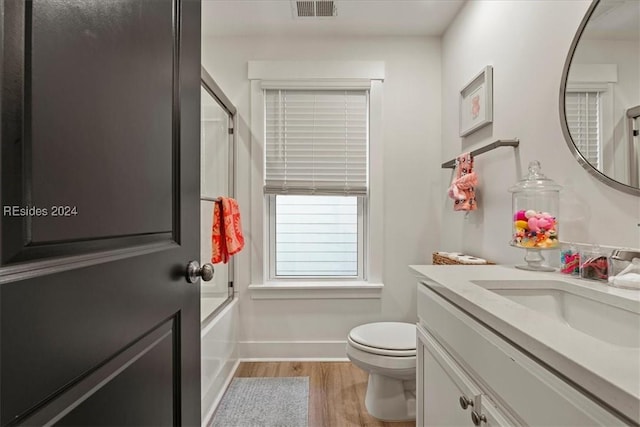 full bathroom featuring enclosed tub / shower combo, wood-type flooring, vanity, and toilet