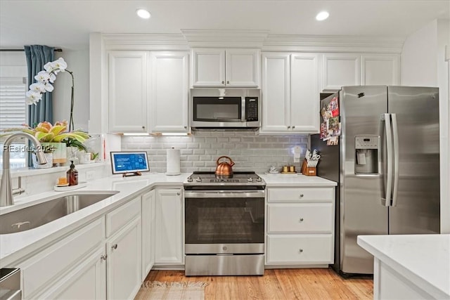 kitchen featuring white cabinetry, sink, decorative backsplash, and appliances with stainless steel finishes