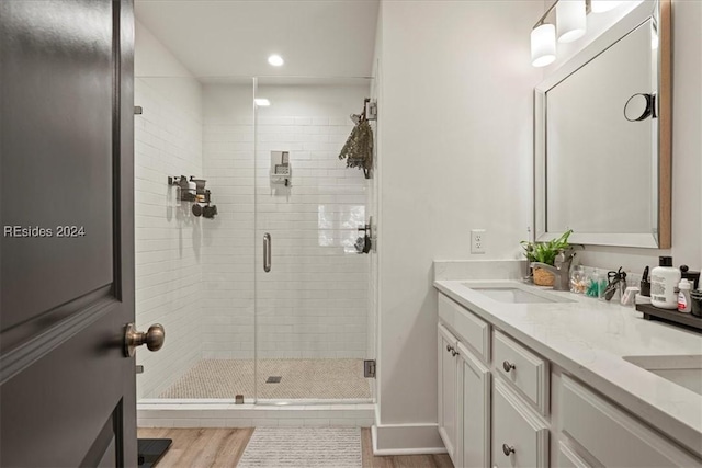 bathroom featuring vanity, hardwood / wood-style floors, and a shower with shower door