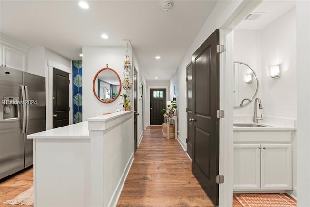 hallway featuring sink and light hardwood / wood-style flooring