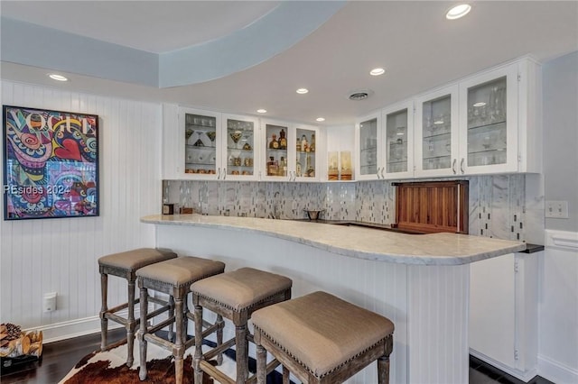 bar with white cabinetry and dark hardwood / wood-style flooring