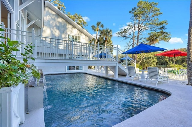 view of swimming pool with a wooden deck and pool water feature