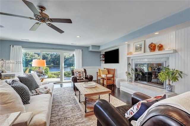 living room with ceiling fan, hardwood / wood-style floors, and a high end fireplace