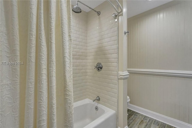 bathroom featuring hardwood / wood-style flooring, toilet, and shower / bath combo with shower curtain