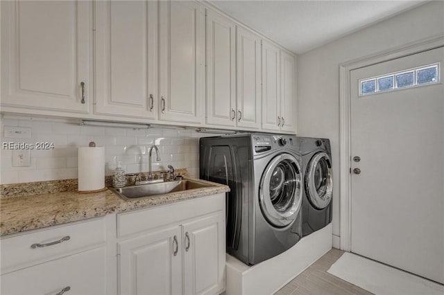 washroom featuring cabinets, sink, and washer and clothes dryer