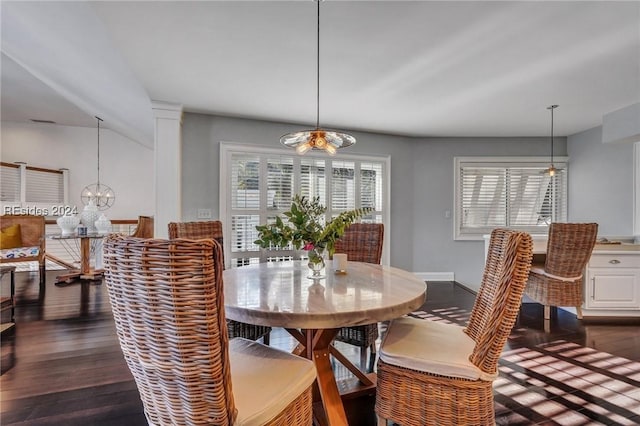 dining space featuring dark wood-type flooring and a chandelier