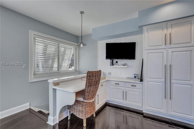 dining space featuring dark wood-type flooring and built in desk