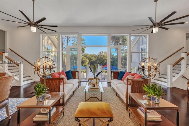 sunroom / solarium featuring ceiling fan with notable chandelier and a healthy amount of sunlight