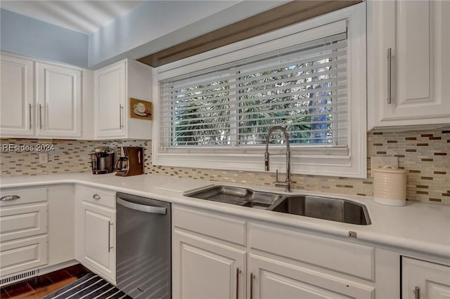 kitchen featuring white cabinetry, sink, stainless steel dishwasher, and decorative backsplash