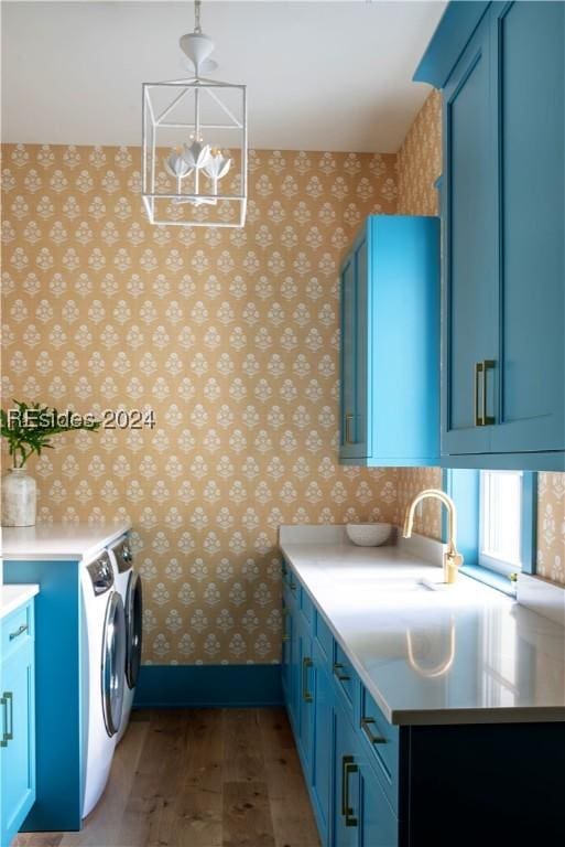 laundry area with cabinets, sink, hardwood / wood-style floors, and independent washer and dryer