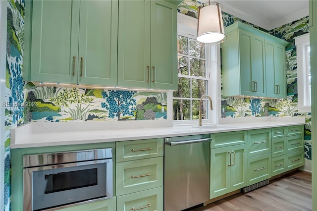 kitchen featuring pendant lighting, sink, stainless steel dishwasher, and green cabinets