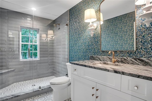 bathroom with vanity, toilet, and a tile shower