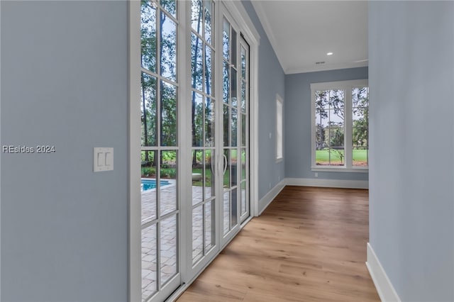 entryway featuring ornamental molding and light hardwood / wood-style floors