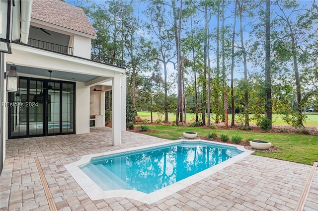 view of pool featuring a lawn, a patio, and ceiling fan