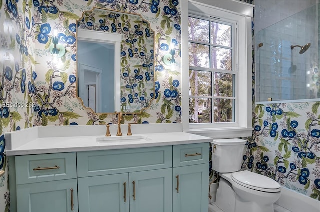 bathroom with vanity, tiled shower, and toilet