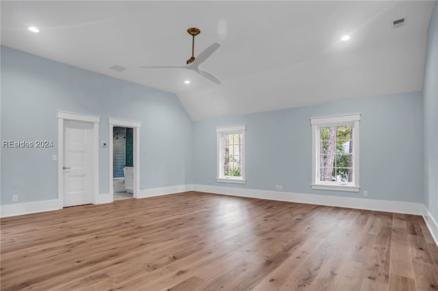 empty room featuring ceiling fan, a healthy amount of sunlight, lofted ceiling, and light hardwood / wood-style flooring