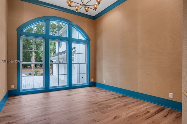 entryway featuring ornamental molding, a notable chandelier, and light hardwood / wood-style flooring