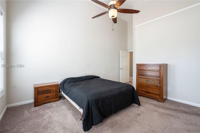 carpeted bedroom with ceiling fan and vaulted ceiling