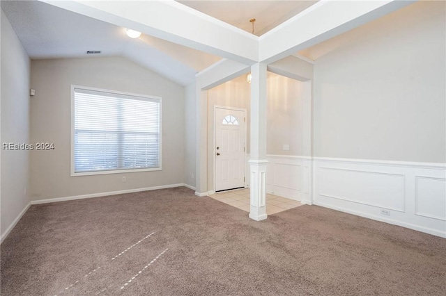 carpeted foyer featuring vaulted ceiling