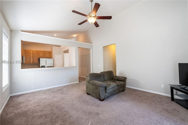 living area with ceiling fan, light colored carpet, and a healthy amount of sunlight