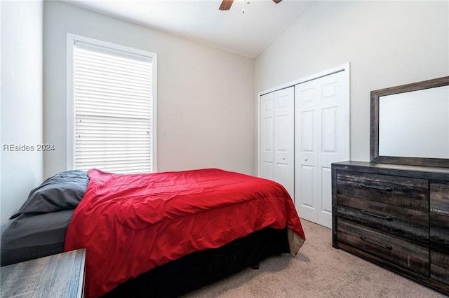 carpeted bedroom featuring multiple windows, vaulted ceiling, ceiling fan, and a closet