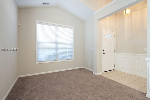 entrance foyer with light tile patterned floors and vaulted ceiling