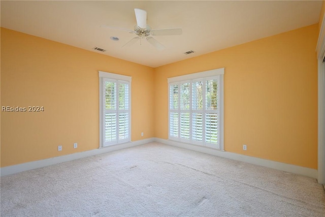 carpeted spare room with ceiling fan