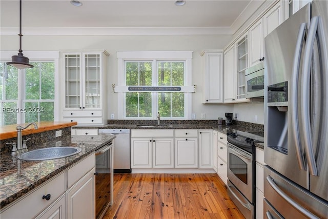 kitchen featuring sink, dark stone counters, white cabinets, and appliances with stainless steel finishes