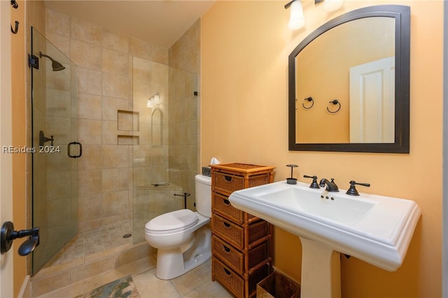 bathroom featuring a shower with shower door, sink, tile patterned floors, and toilet