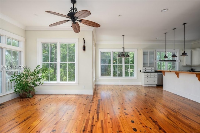 unfurnished living room featuring ceiling fan, ornamental molding, and hardwood / wood-style floors