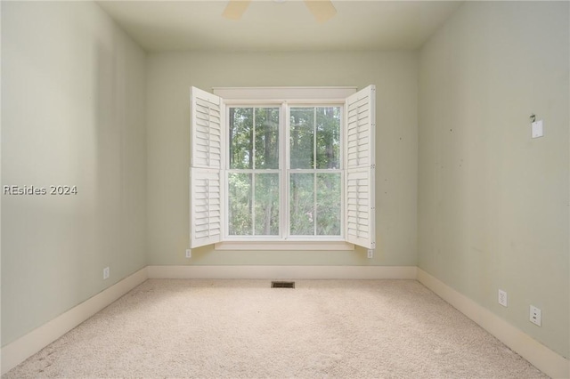 carpeted empty room featuring ceiling fan