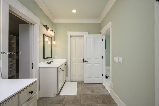 bathroom featuring tile patterned flooring, ornamental molding, and vanity