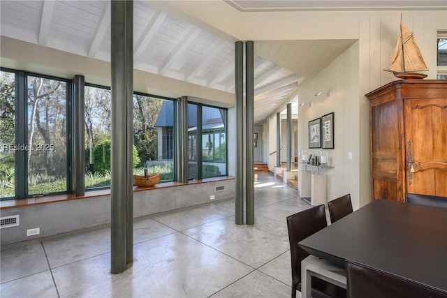 sunroom / solarium featuring vaulted ceiling with beams