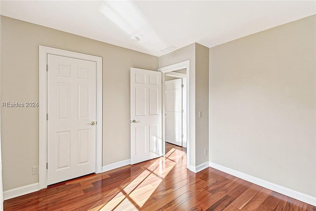 unfurnished bedroom with hardwood / wood-style flooring