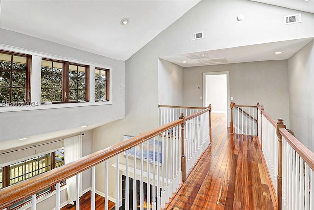 hall featuring hardwood / wood-style flooring and high vaulted ceiling