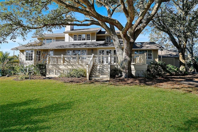 rear view of house with a deck and a lawn