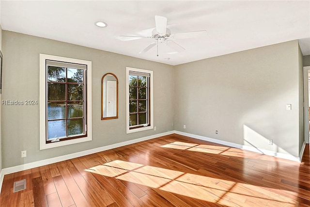 unfurnished room featuring ceiling fan, a healthy amount of sunlight, and wood-type flooring