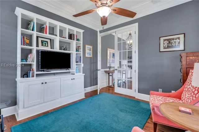 sitting room featuring dark wood-type flooring, crown molding, ceiling fan with notable chandelier, and french doors