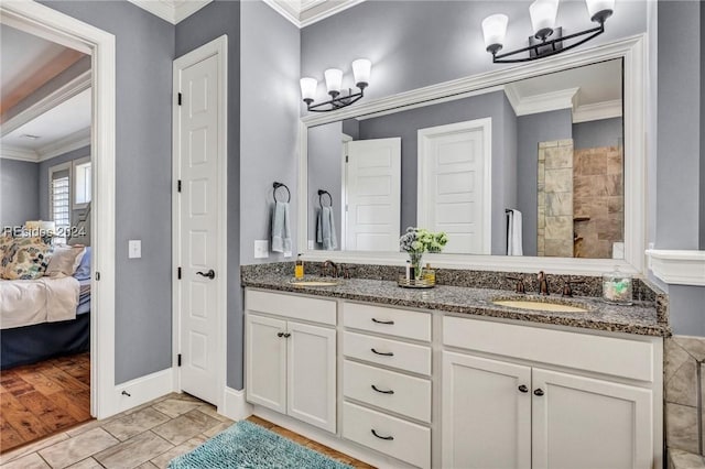 bathroom featuring vanity, tile patterned flooring, crown molding, and a notable chandelier