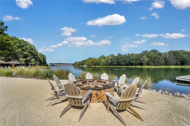 view of dock with a water view, a patio area, and a fire pit