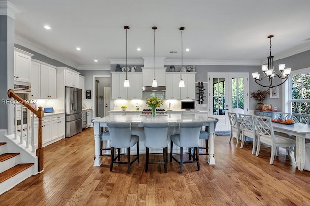 kitchen featuring hanging light fixtures, stainless steel appliances, and a spacious island