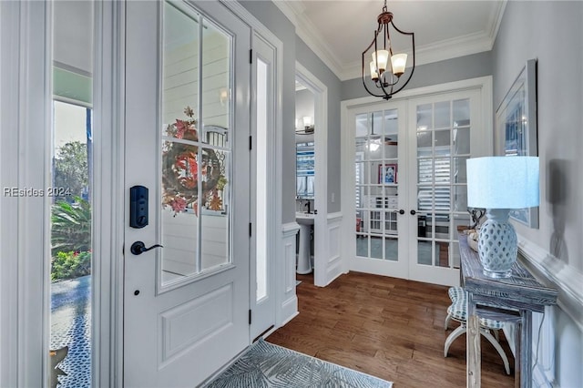 entryway with crown molding, hardwood / wood-style floors, a notable chandelier, and french doors