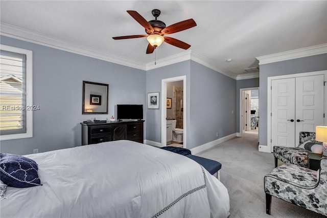 carpeted bedroom featuring ceiling fan, crown molding, ensuite bath, and a closet