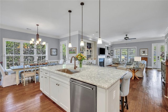 kitchen with sink, white cabinetry, hanging light fixtures, a center island with sink, and stainless steel dishwasher